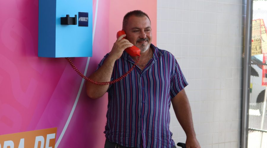 Visitante da Feira dos Importados, que passava pelo local onde estava instalado o Big Fone, tira foto falando ao telefone.